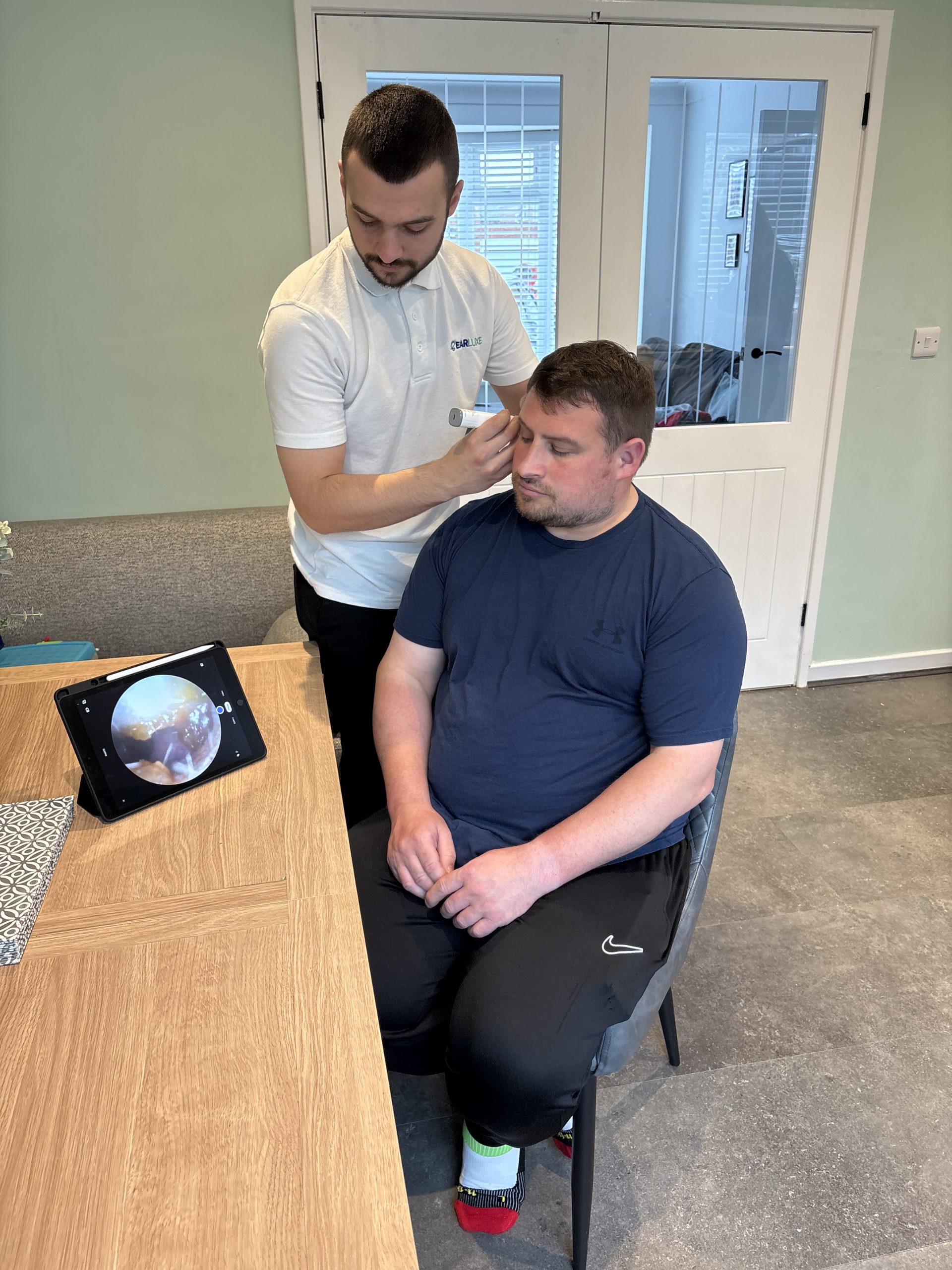 Earluxe practitioner performing ear wax removal Wallsend microsuction home visit